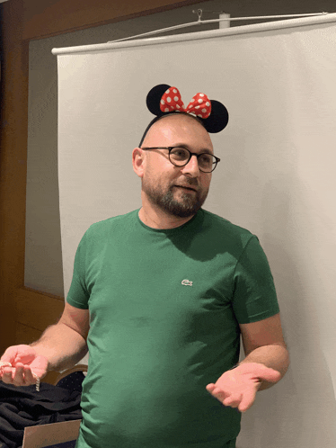 a man wearing a minnie mouse headband and a lacoste shirt