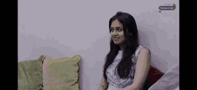 a woman is sitting on a couch in front of a wall that says mocha city on it