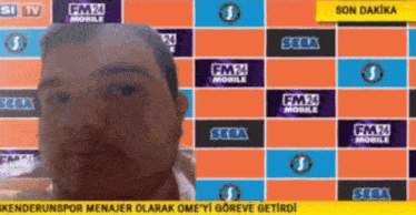 a man is standing in front of a screen that says fm 24 mobile