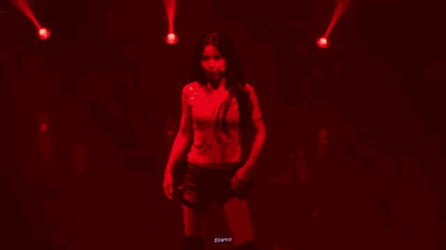 a woman in a nike bra and shorts is dancing on a stage .