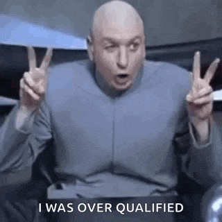 a bald man is giving a peace sign with his hands while sitting in a chair .
