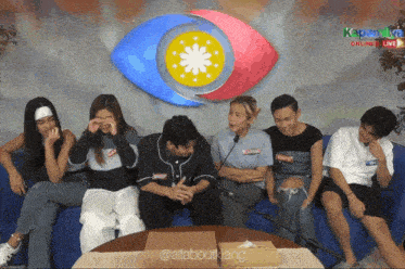 a group of people sitting on a couch in front of a big eye that says kapamilya