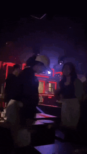 a group of people are sitting in a dark room with a yellow light shining through the ceiling
