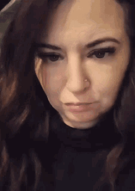 a close up of a woman 's face with a nose ring on it