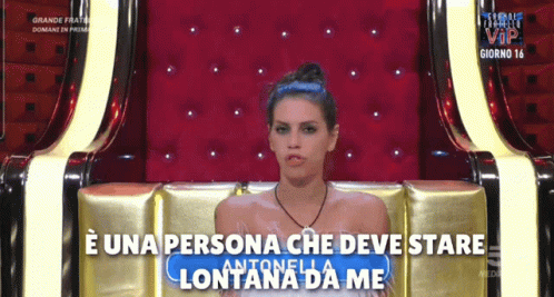 a woman sits in a chair with the words e una persona che deve stare lontana da me on the bottom