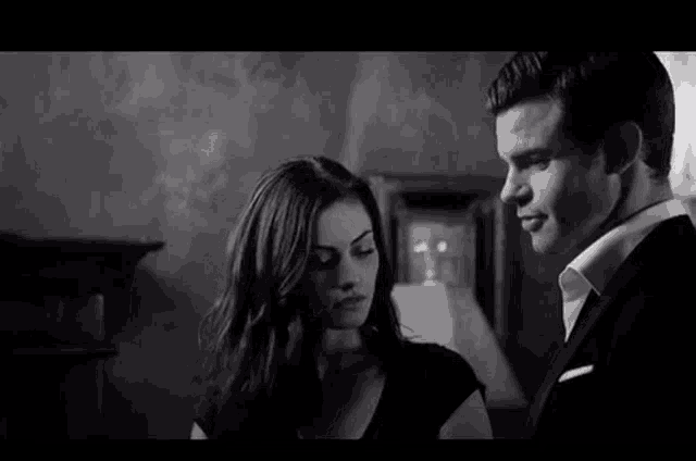 a black and white photo of a man and a woman looking at each other