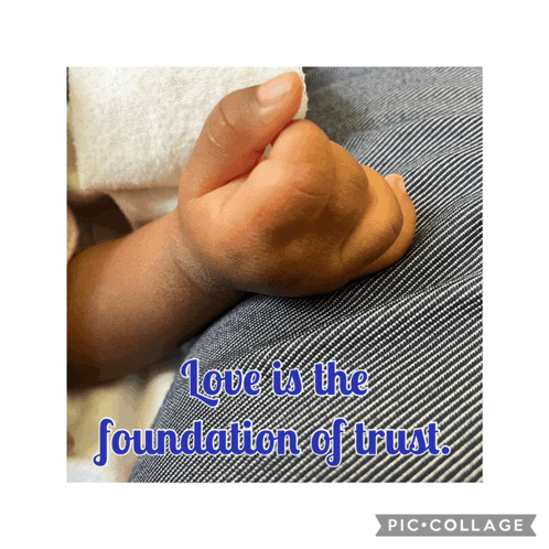 a picture of a baby 's hand with the words love is the foundation of trust above it