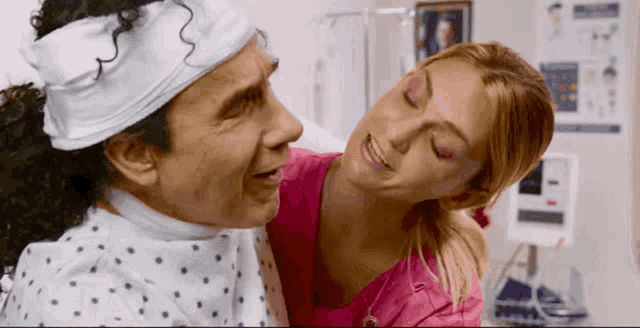 a man with a bandaged head is being comforted by a woman
