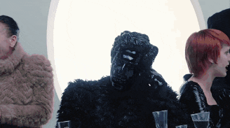 a man in a fur coat stands next to a monkey