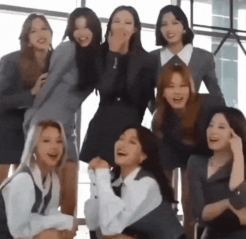 a group of young women are posing for a picture and laughing together .
