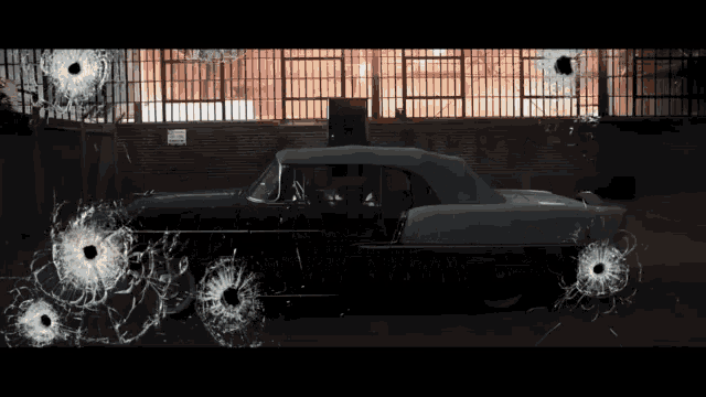 a car with bullet holes in it is parked in front of a building