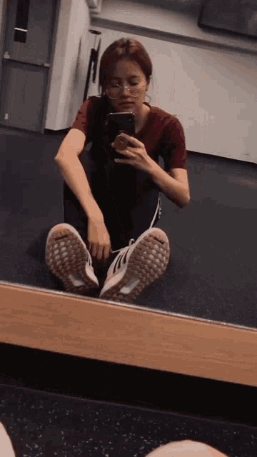 a woman taking a picture of herself in a mirror