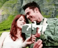 a man and a woman are taking a selfie with a camera .