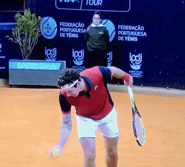 a man is holding a tennis racquet in front of a sign that says speed kmh