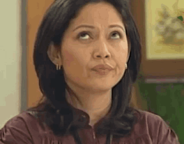 a woman is making a funny face and looking up at the sky .
