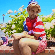 a man in an american flag outfit is sitting on a wall