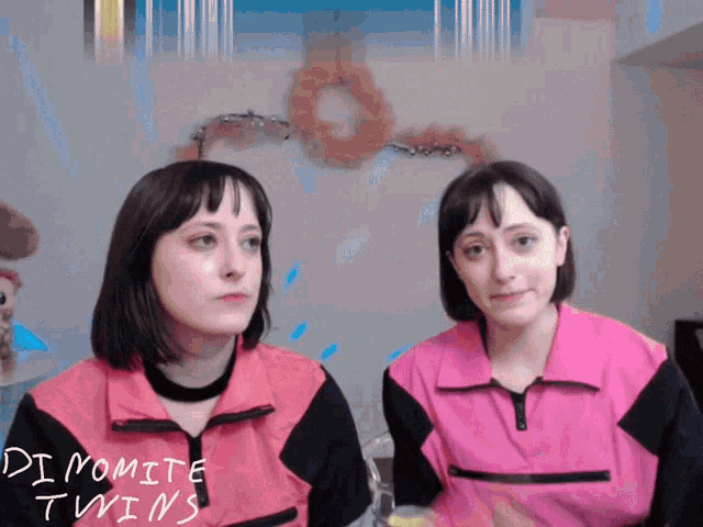 two women in pink jackets with dynamite twins written on them