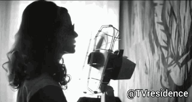 a black and white photo of a woman holding a fan with the hashtag @tvresidence