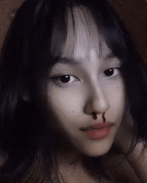 a close up of a girl 's face with blood on her nose