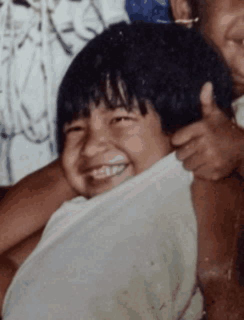 a child is smiling and giving a thumbs up sign