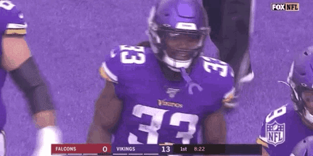 a vikings football player wearing a purple jersey with the number 33 on it