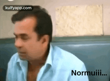 a man in a blue shirt is sitting in a chair in a restaurant .