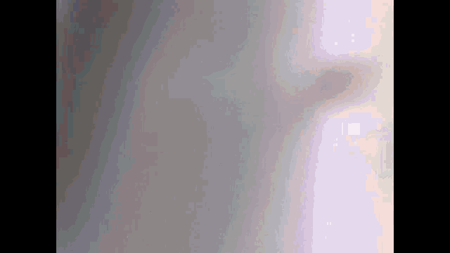 a close up of a gray and pink background with a blurred image of a person 's face .