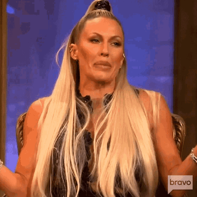 a woman with long blonde hair is sitting in a chair with bravo written on the bottom