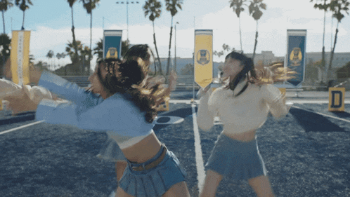 a group of girls are dancing on a field with a banner that says ' california ' on it