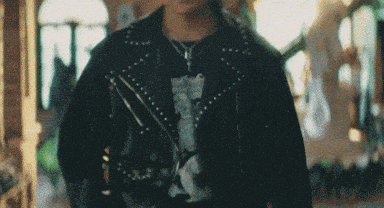 a man wearing a black leather jacket and a black t-shirt with a cat on it