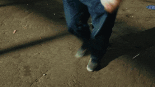 a person in blue jeans is holding a can of sprite
