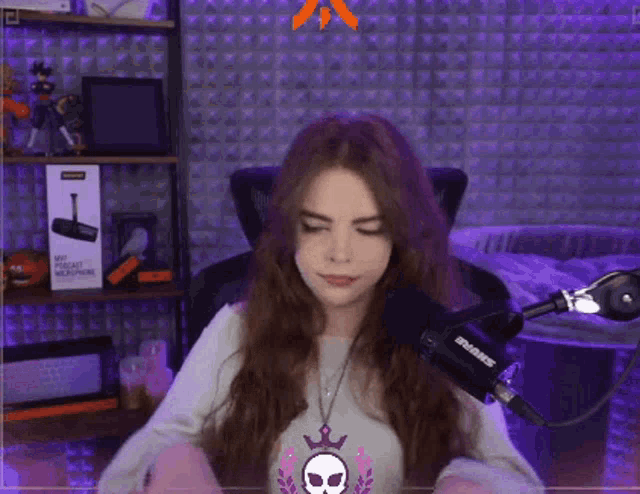 a woman sitting in front of a shure microphone in a room