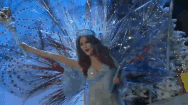 a woman in a fairy costume is standing on a stage with her wings spread out .