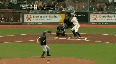 a baseball game is being played in front of a dominican hospital sign