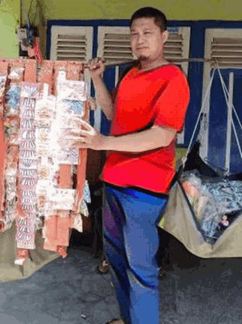 a man in a red shirt and blue pants is standing in front of a display of candy