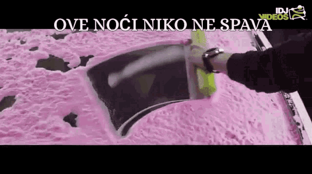 a person is cleaning a car with a sponge and the words ove noci niko ne spava are above them