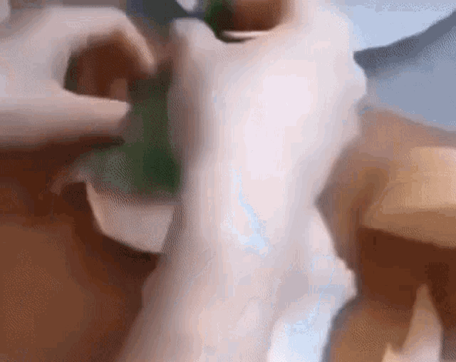 a close up of a person 's hand holding a green object .