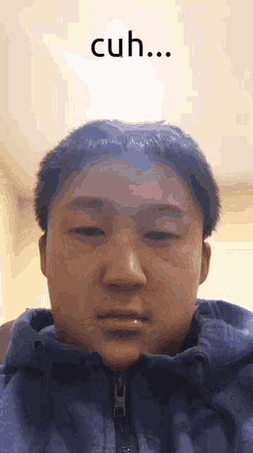a young man with a blue jacket is looking at the camera with the words cuh above him
