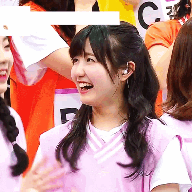a girl wearing headphones smiles in front of a sign that says c on it