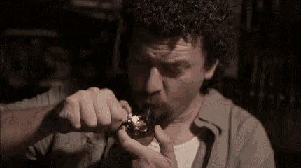 a man is smoking a cigarette with a lighter in his mouth .