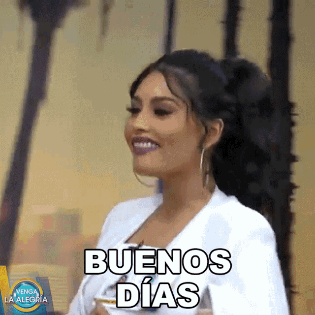 a woman says buenos dias while smiling and holding a glass