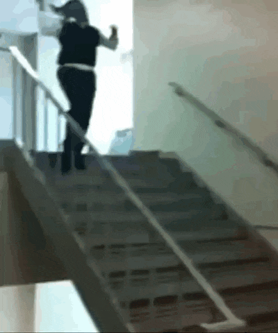 a woman is walking down a set of stairs with a railing .