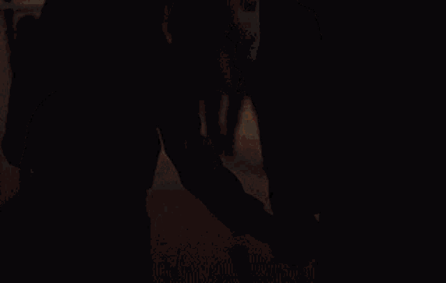a silhouette of a man and a woman standing in a crowded hallway