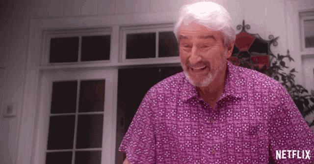 a man wearing a purple shirt with a netflix logo on the bottom