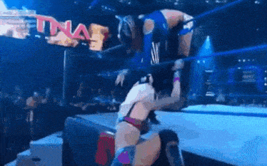 two women are wrestling in a ring with a sign that says tna .