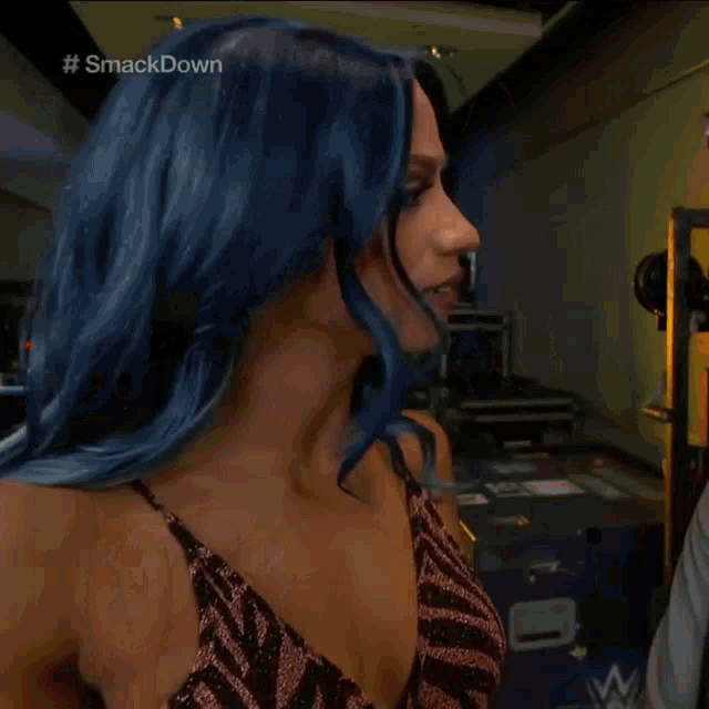 a woman with blue hair is wearing a zebra print dress and looking up .