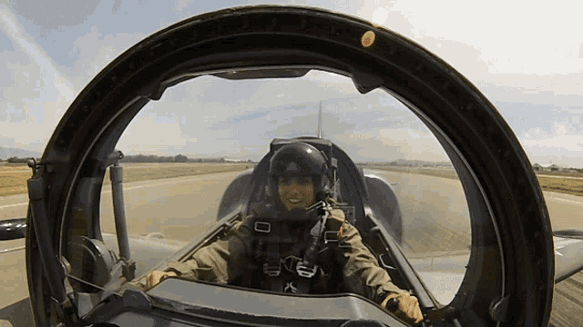 a man in a military uniform is sitting in a cockpit