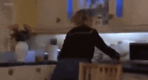 a blurry picture of a woman standing in a kitchen