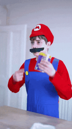 a boy in a mario costume holds a box