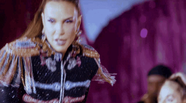 a woman in a black and gold outfit is dancing